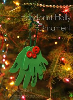 handprint holly ornament hanging from a christmas tree