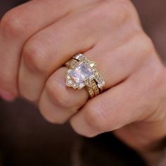 a close up of a person's hand with a ring on it