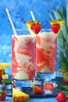 two drinks with strawberries and pineapple garnish