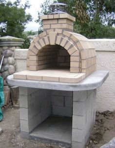 an outdoor brick pizza oven built into the side of a building