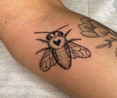 a bee with a heart tattoo on it's arm