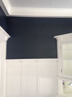 an empty room with blue walls and white trim on the wall, painted in dark blue