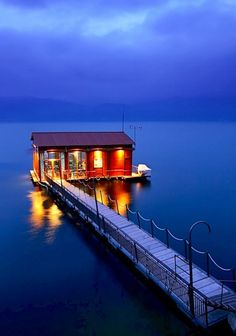 a houseboat floating on top of a large body of water under a cloudy sky