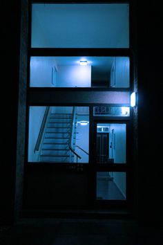 an open door with stairs lit up at night