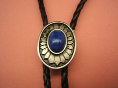 "- Southwestern Concho Bolo Tie, - Silver Plated with Antique Finish, Anti-Tarnish Added for Lasting Beauty. - Lapis or Ivory Acrylic Cabachon, - Black or Brown, 38 to 42 inch, Vinyl Leatherlike Cord with Silver Tone Cord End Tips, - \"NEW\" Tension Bolo Back, which is easier to use and helps the cord to keep from fraying. - Concho is Approx. 1 1/4 in. long by 1 in. wide, - #1084B-9, - Affordably priced! - COMES BOXED! Free Shipping* (USPS First Class Mail, US Customers) *(see my shipping policy Elegant Concho Jewelry For Western-themed Events, Bohemian Concho Jewelry For Rodeo, Traditional Adjustable Jewelry For Rodeo, Bohemian Concho Jewelry For Western-themed Events, Traditional Concho Jewelry For Western-themed Events, Blue Concho Jewelry For Western-themed Events, Bohemian Silver Bolo Ties For Western-themed Events, Silver Bohemian Bolo Ties For Western-themed Events, Silver Bohemian Bolo Tie For Western-themed Events