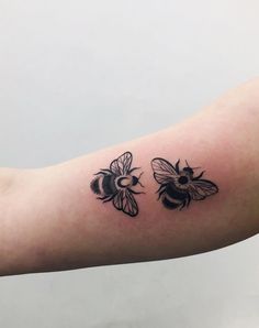 a black and white photo of two bees on the arm