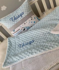 two personalized baby blankets on top of a crib