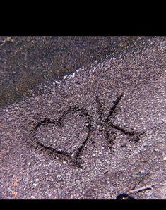 a heart drawn on the ground next to a street sign