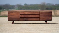 a wooden dresser sitting on top of a sandy beach