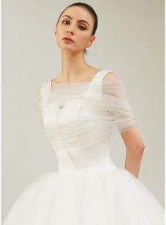 a woman in a white dress posing for the camera with her hands on her hips