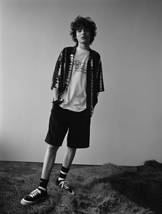 a man standing in front of a wall wearing shorts and a t - shirt with the words instagram on it