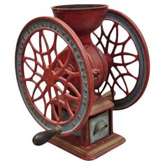 an old fashioned red spinning machine on a white background