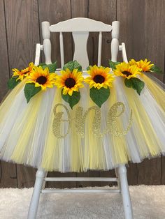 a white chair with yellow tulle and sunflowers on it