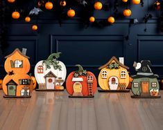 several pumpkin shaped houses sitting on top of a wooden floor