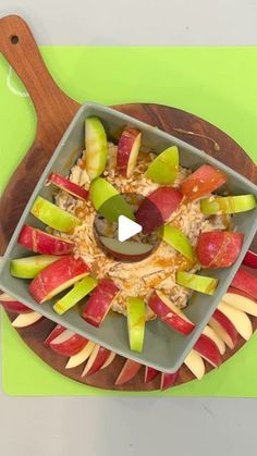 an apple and cheese appetizer on a wooden platter with a green cutting board