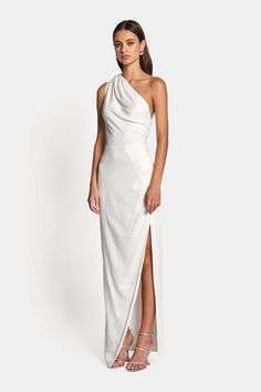 The May Draped One Shoulder Gown in White is draped to flatter with a glamorous elongating silhouette, cross-over skirt and side-seam split. Model is 176cm tall and wears a size 6.Fits true to size. - 96% Viscose 4% Spandex- 100% Viscose Lining- Shoulder Pleating- Side-seam Pleating- Cross-over Skirt- Side-seam Split- Floor Length- Fully Lined White One Shoulder Bridesmaid Dresses, One Shoulder Mother Of The Groom Dresses, White Long Dresses, Long One Shoulder Dress, Wedding Dress One Shoulder, Greek Style Dress, White One Shoulder Dress, One Shoulder White Dress, Asymmetrical Bridesmaid Dress