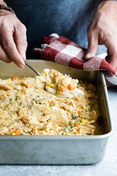 a person is spooning food out of a casserole dish