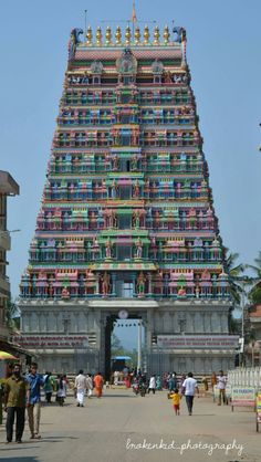 a very tall colorful building with people walking around it