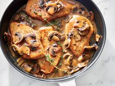 a skillet filled with chicken and cheese covered in sauce, garnished with parsley