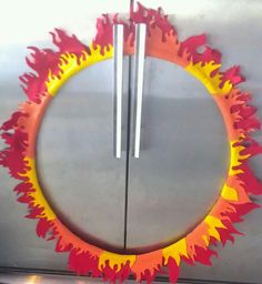 an orange and yellow fire ring with two sticks sticking out of it's center