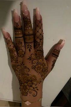 a woman's hand with henna tattoos on it