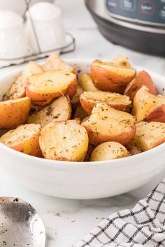 a white bowl filled with potatoes on top of a table