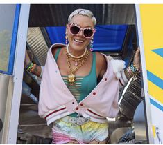 a woman with sunglasses and jewelry standing in the doorway of a food truck