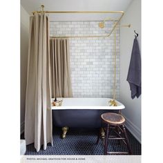 a bathroom with a bathtub, stool and shower curtain