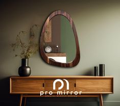 a mirror on the wall next to a table with a vase and clock in it