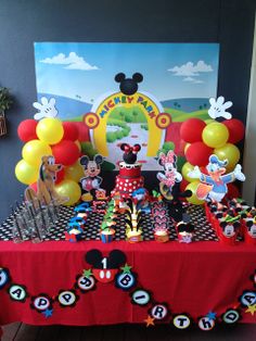 a mickey mouse birthday party with balloons and decorations