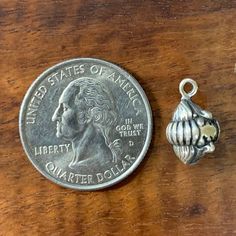 a penny sitting next to a sea shell charm