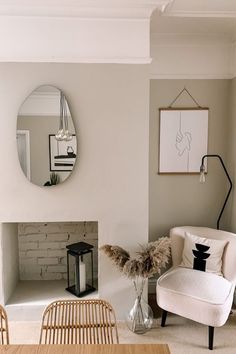 a living room filled with furniture and a fire place in front of a mirror on the wall