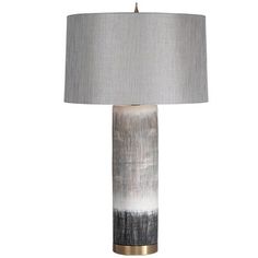 a table lamp with a grey and white shade on the top, gold trim around the base