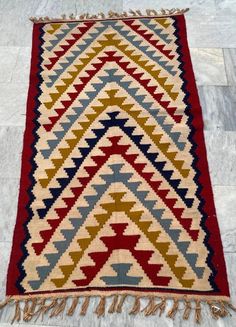 a multicolored rug with fringes on the floor