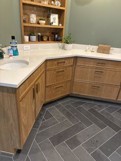 a large bathroom with wooden cabinets and tile flooring, along with gray tiles on the floor