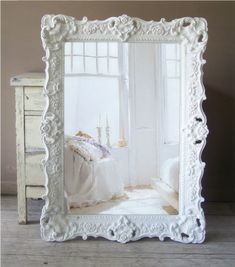 a white frame with an image of a bed in the middle and a window behind it