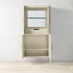 an empty white cabinet sitting on top of a hard wood floor next to a wall