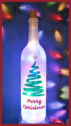 a lighted bottle with a merry christmas tree on the top and lights in the background