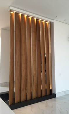 a room divider made out of wood with lights on the side and behind it