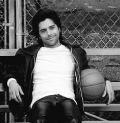 a man sitting on a bench holding a basketball