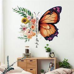 a bedroom with a bed, dresser and butterfly wall decal