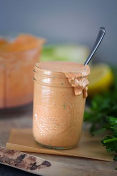 a jar filled with dressing next to a cutting board