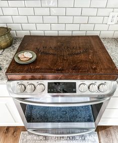 a wooden cutting board sitting on top of an oven