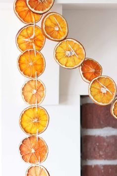 orange slices hanging from a string in front of a brick wall