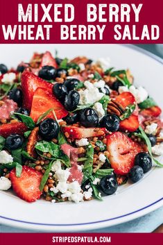 mixed berry wheat berry salad on a white plate with blueberries and feta cheese