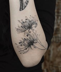 a woman's arm with a butterfly and flower tattoo on the left side of her arm