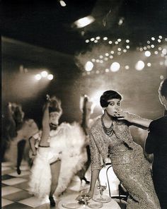 an old black and white photo of people dancing in a dance hall with disco lights overhead