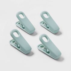 four mint green plastic clips on a white surface