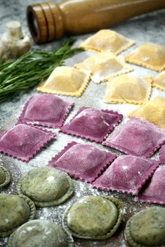 some ravioli sitting on top of a table next to a rolling pin and garlic