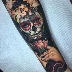 a woman's arm with a skull and flowers on it